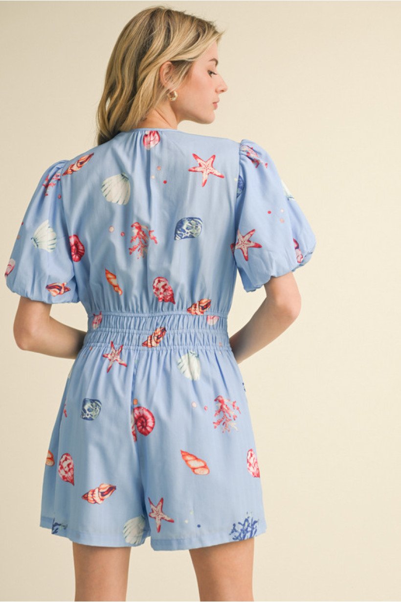 Blue shell print romper with puff sleeves, ideal for coastal boutique clothing and tropical vacation dresses.