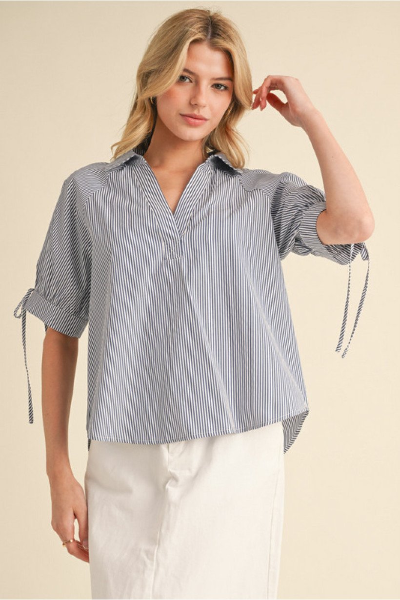 Stylish navy striped top with bow tie cuffs, perfect for coastal boutique clothing and curated women's fashion.