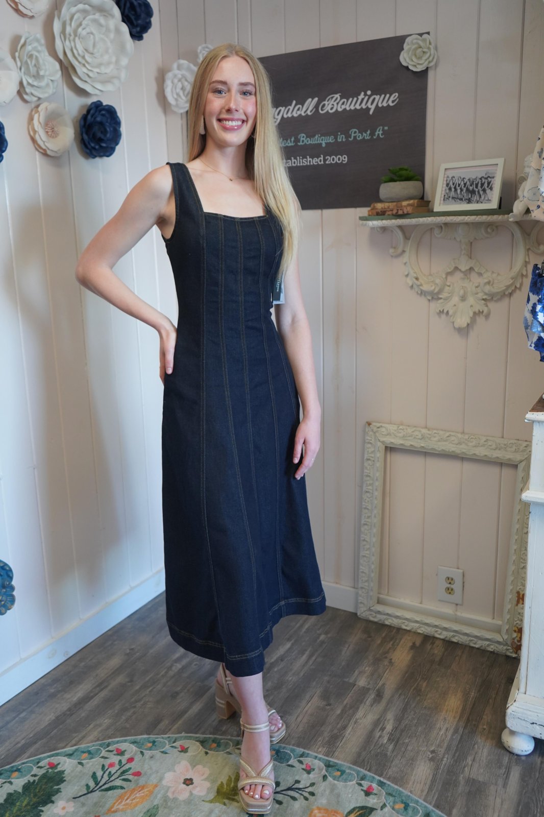 Stylish woman in indigo smocked-back midi dress from coastal boutique, perfect for beach outings and tropical vacations.