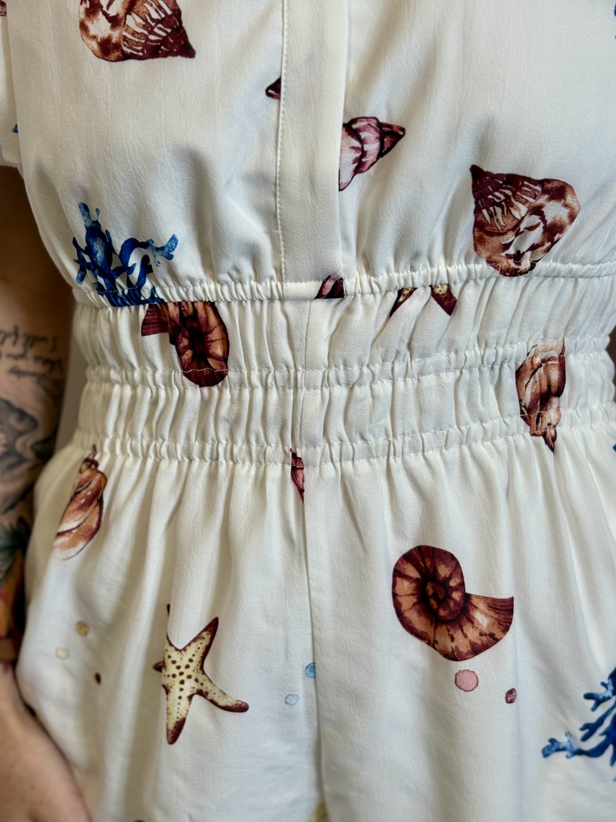 Off-White Shell Print Romper with puff sleeves and cinched waist, perfect for coastal boutique clothing and tropical vacation dresses.
