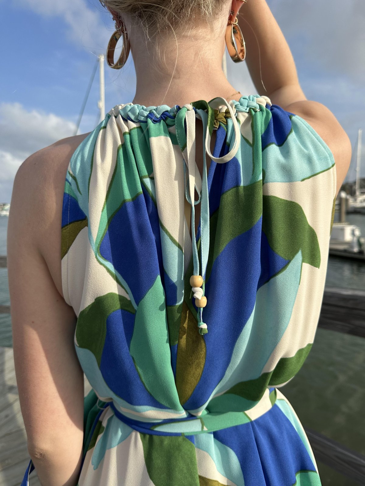 Back detail of the Marisol Dress showcasing tropical print and knot-detailed neckline, perfect for beach parties and resort wear.