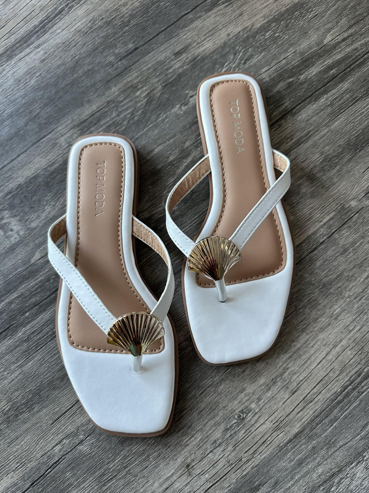 Minnie sandals in white with elegant shell detail, perfect for coastal boutique clothing and tropical vacation dresses.