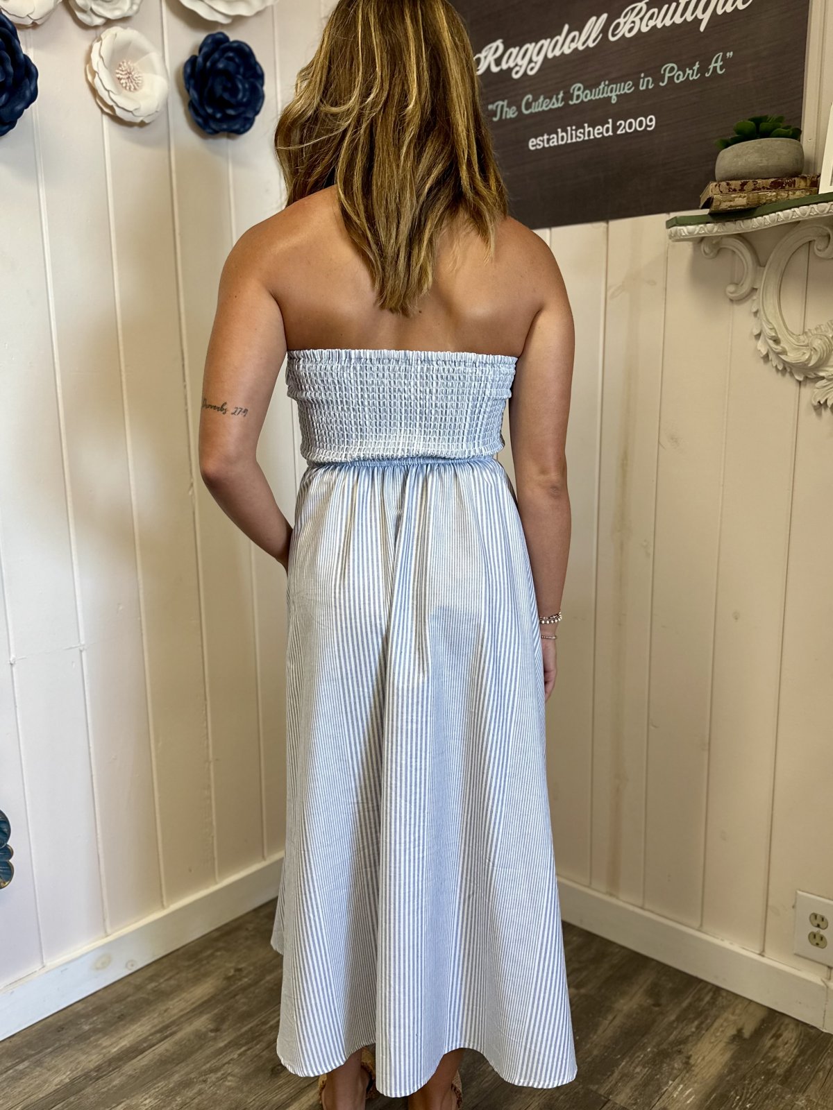 Back view of the Emerson Dress in blue and white stripes, perfect for beach outings and summer events, from a coastal boutique.