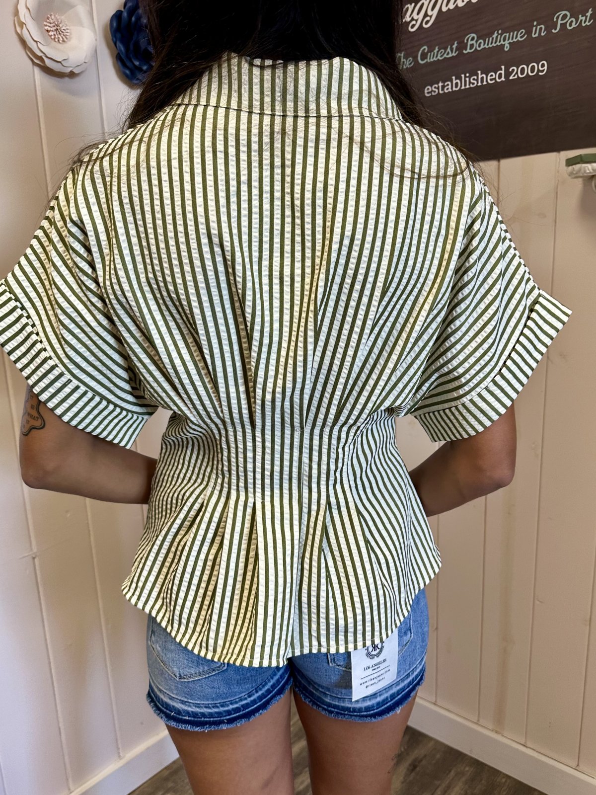 Back view of Kendra Top with olive green stripes and structured collar, styled for trendy coastal fashion.