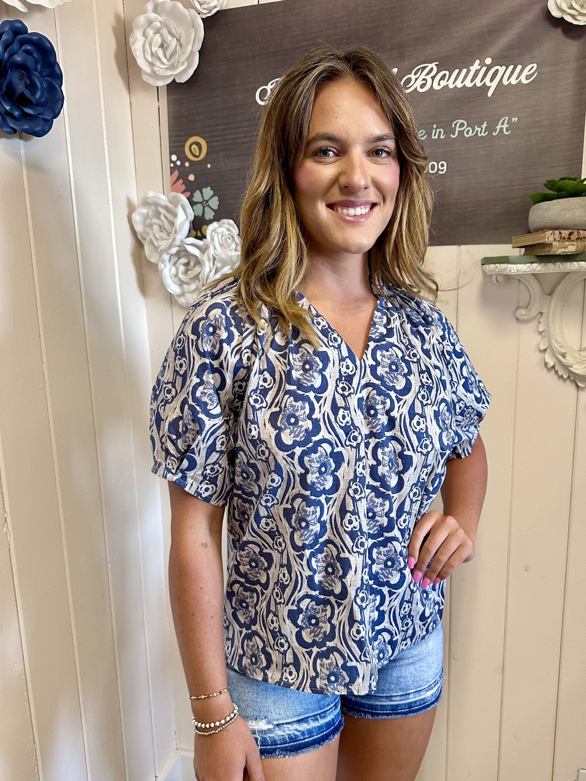 Midnight blue floral pleated top with puff sleeves, stylish for coastal boutique clothing and tropical vacation outfits.