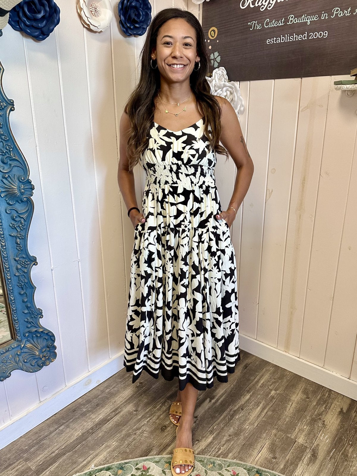 Woman wearing Louisa Dress featuring black and white floral print; perfect for coastal boutique clothing and casual beach outings.