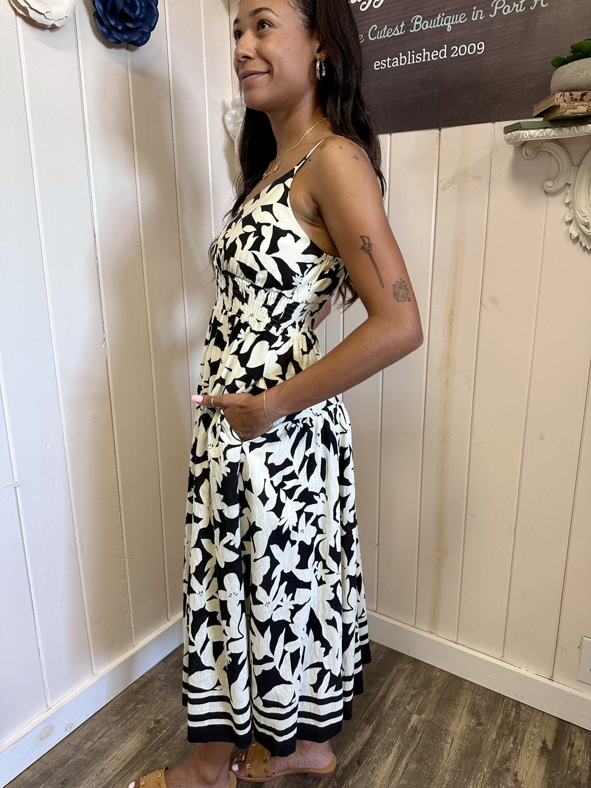 Black and white floral print shoulder strap dress from coastal boutique clothing, perfect for tropical vacations.