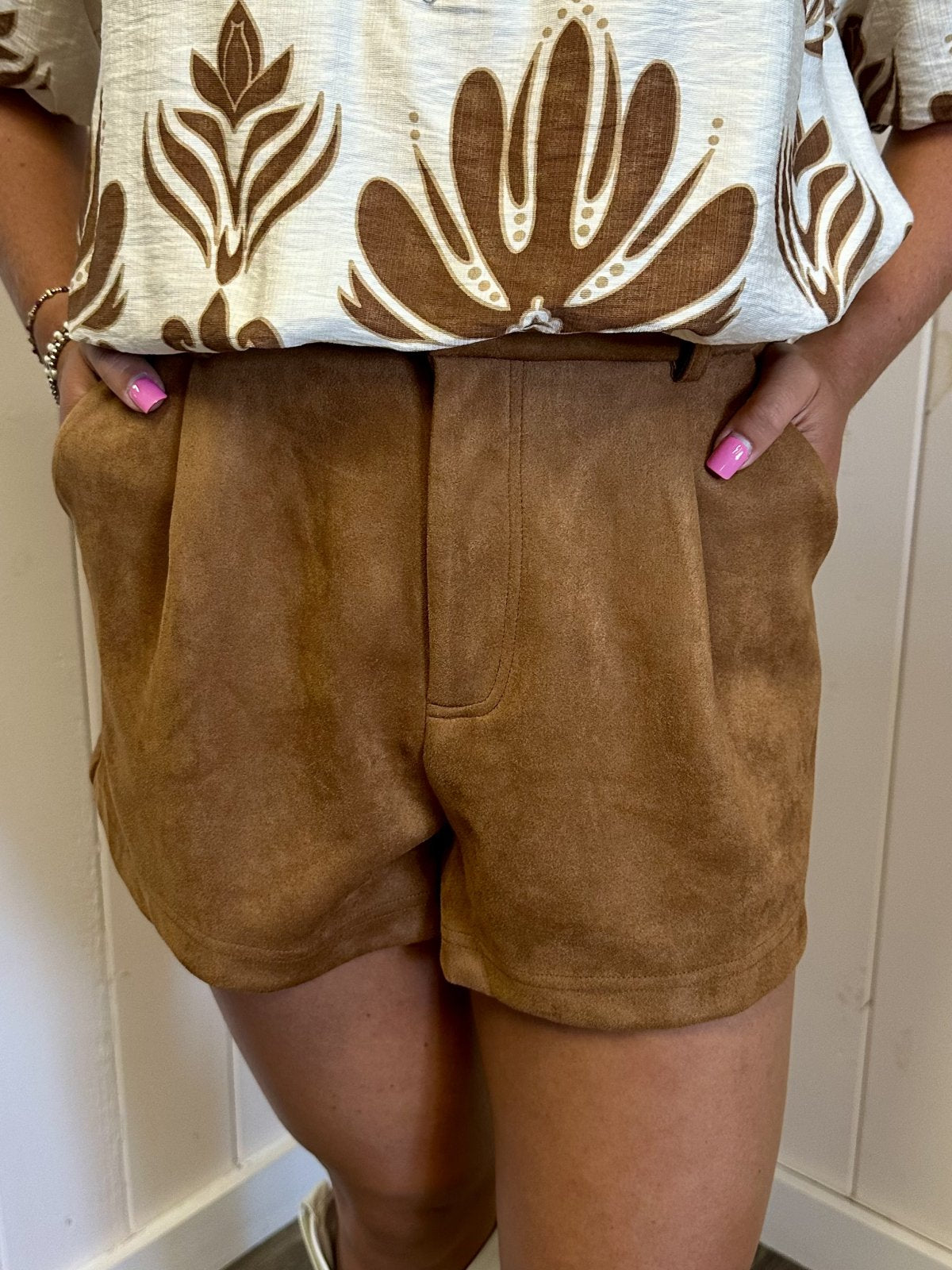 Model wearing Camel High-Waist Suede Shorts from Raggdoll Boutique, showcasing trendy coastal style and comfort.