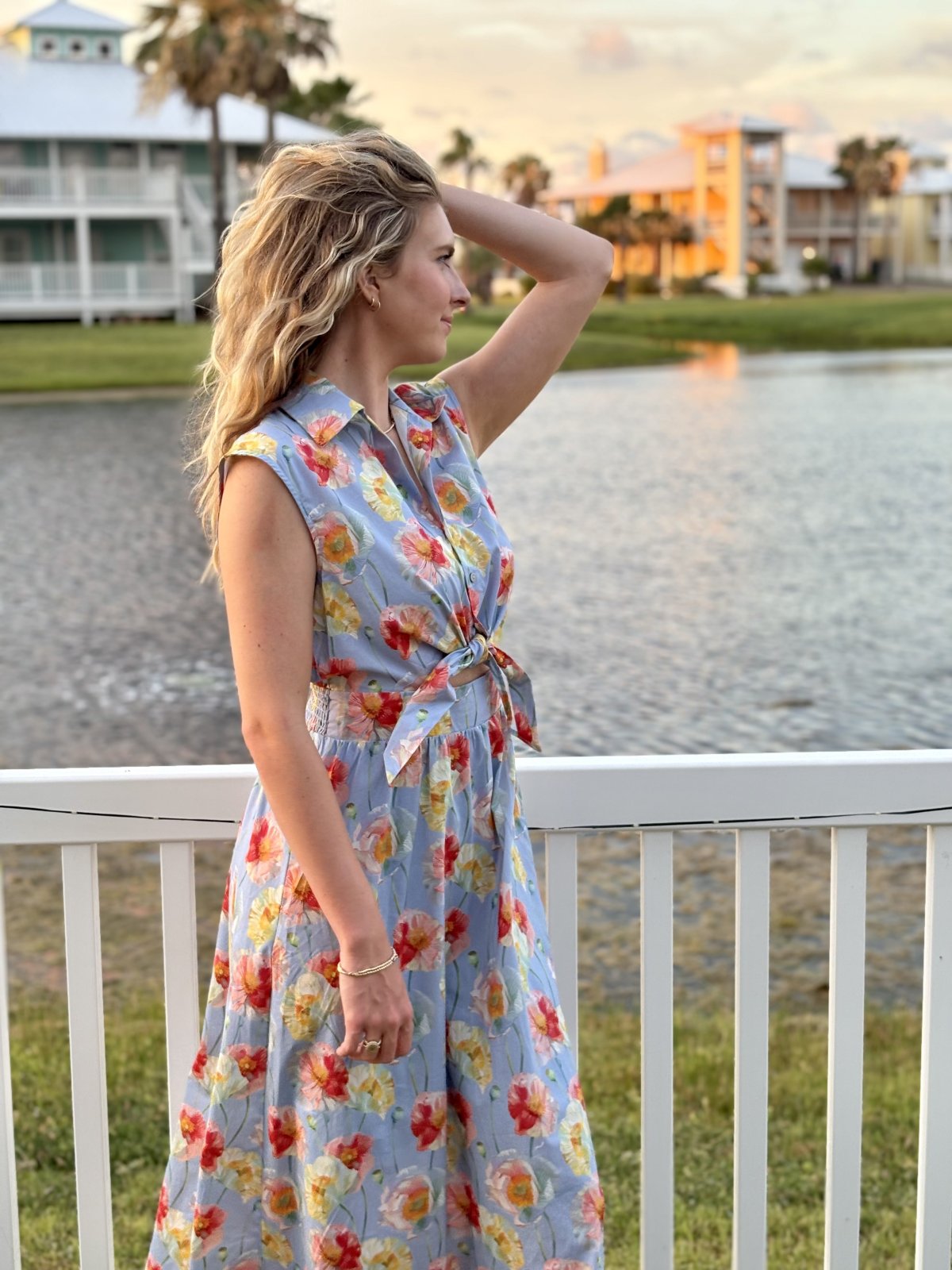 Light blue floral print sleeveless midi dress showcased at a coastal boutique, perfect for tropical vacations and casual outings.