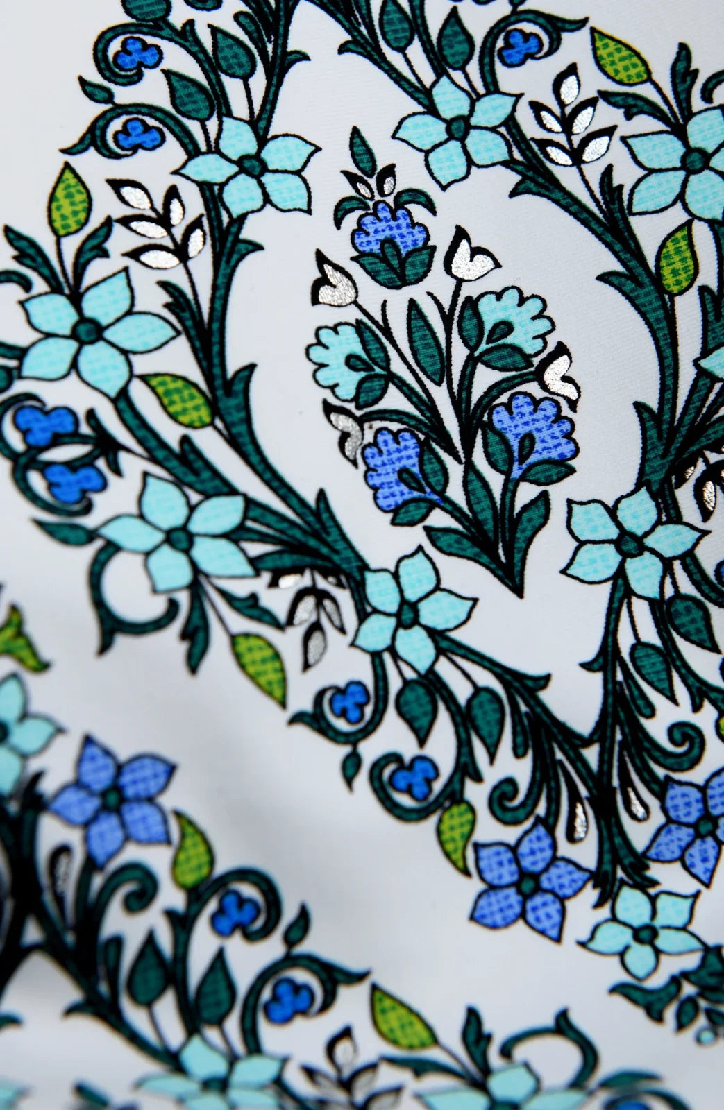 Intricate floral and geometric patterns in blue and green on white, ideal for swimwear boutique and coastal boutique clothing.