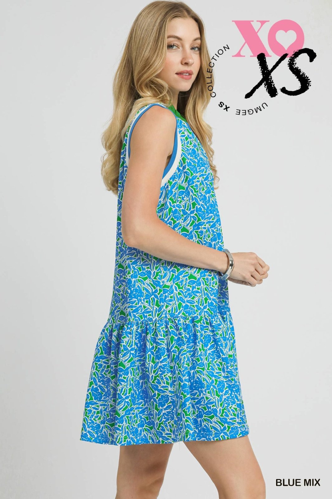 Sleeveless blue and green leaf print dress from a coastal boutique, perfect for stylish tropical vacations and curated women's fashion.