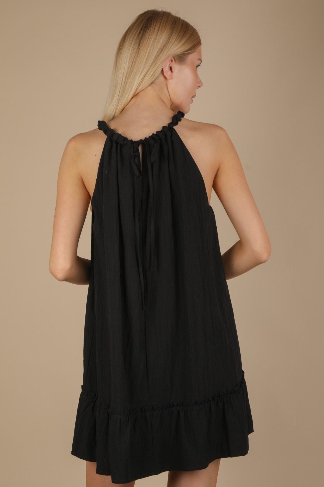 Black halter neck mini dress with ruffle detail, perfect for coastal boutique clothing and tropical vacations.