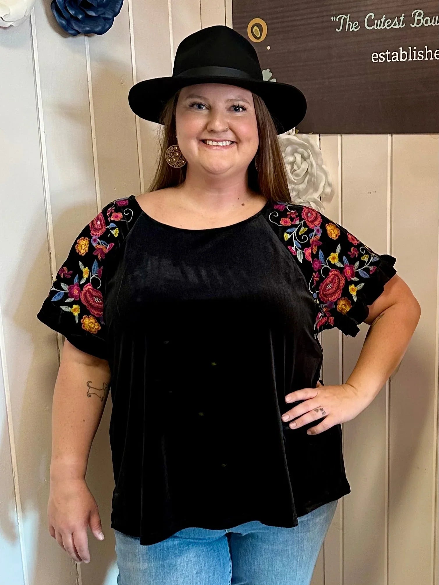 Model in a plus size floral top featuring green patterns, showcasing coastal boutique clothing for curvy women.