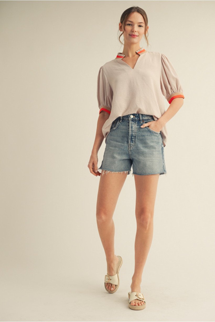 Tan half-sleeve top with orange trim, paired with denim shorts, showcasing coastal boutique clothing style for summer.