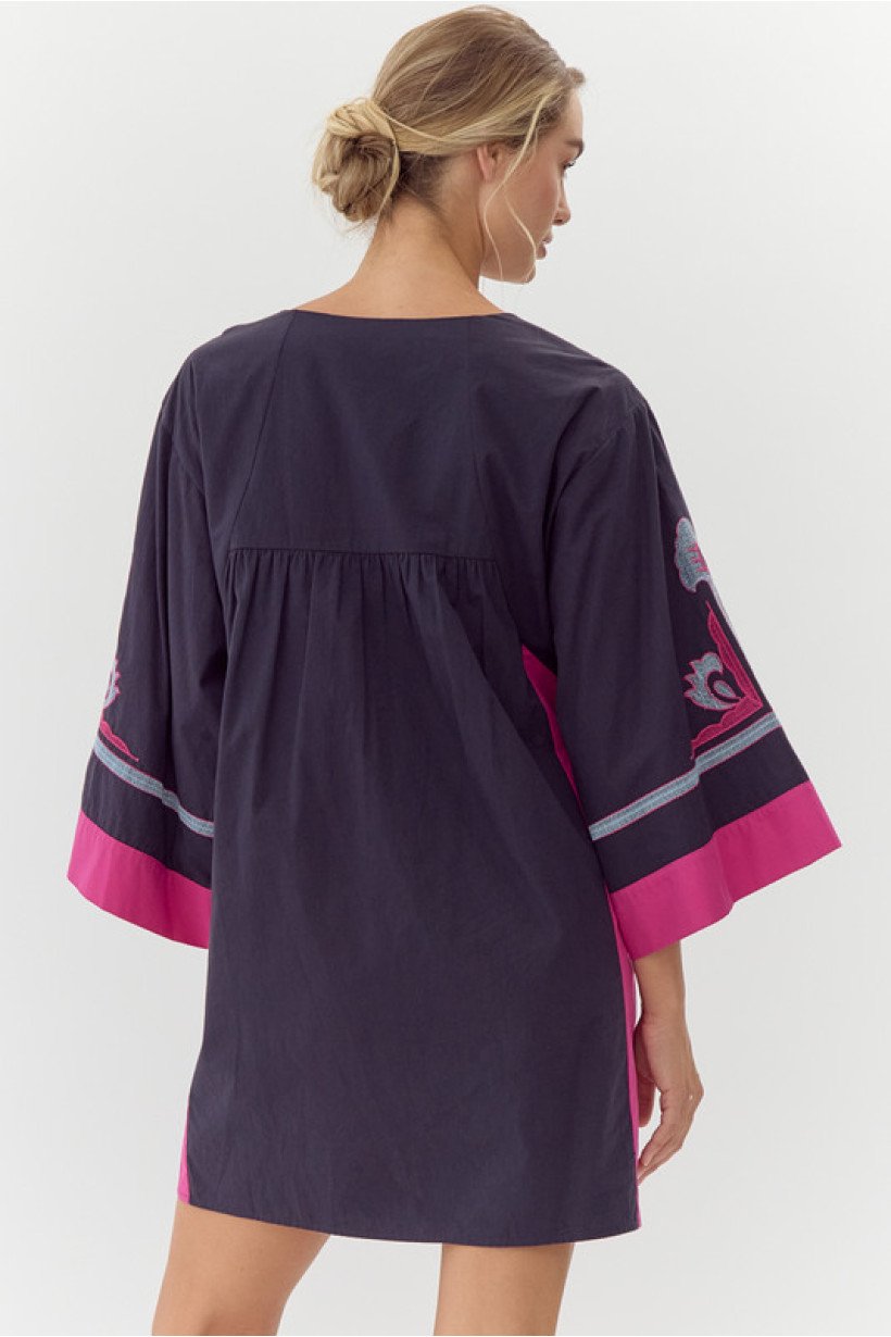 Back view of Layla Dress, a stylish cotton dress perfect for coastal boutiques and tropical vacations, showcasing colorful embroidery.