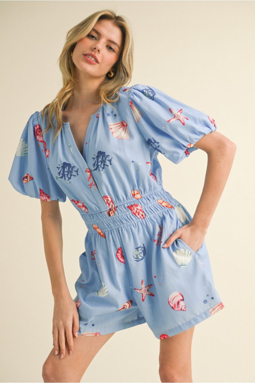 Blue shell print romper with puff sleeves, ideal for beach days and coastal boutique clothing. Perfect for summer fashion.