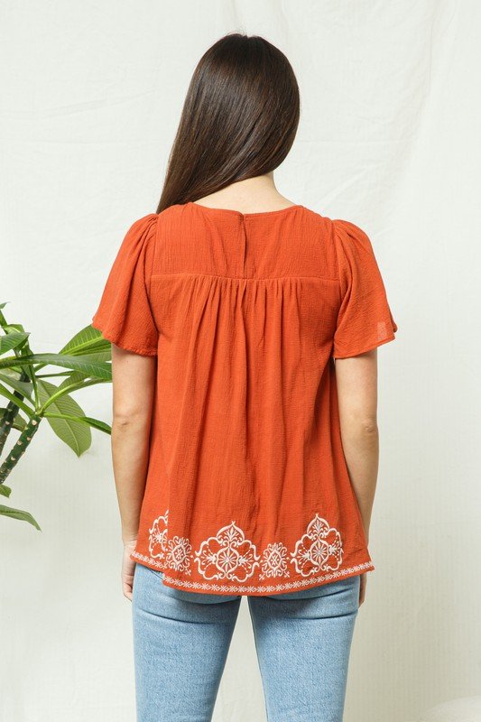 RUST EMBROIDERED TOP featuring contrasting lace, short sleeves, and a pleated hem from Raggdoll Boutique.