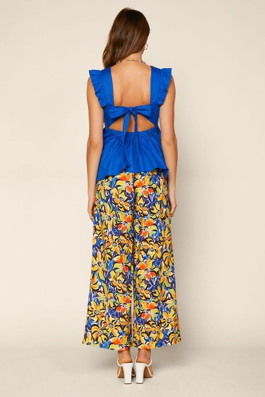 Stylish royal blue bow back top paired with vibrant floral pants, perfect for coastal boutique clothing and tropical vacations.
