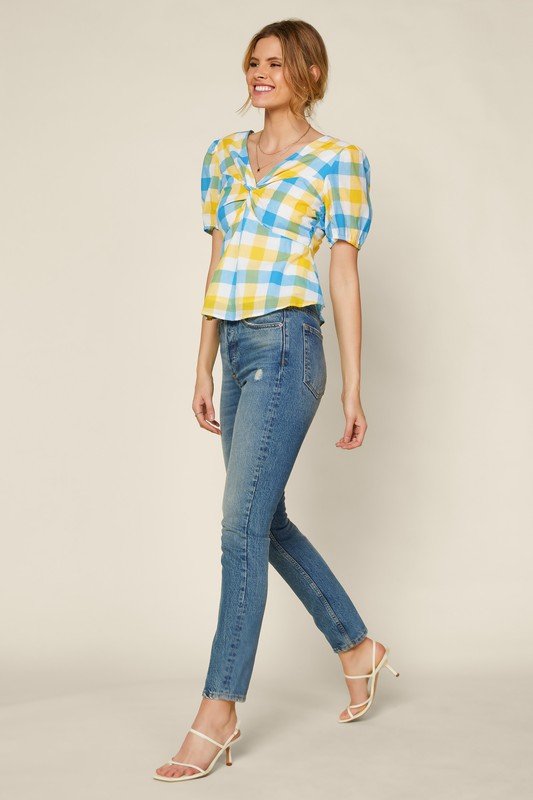 Women in BLUE YELLOW GINGHAM TIE BACK PEPLUM paired with stylish jeans, showcasing trendy coastal style at Raggdoll Boutique.