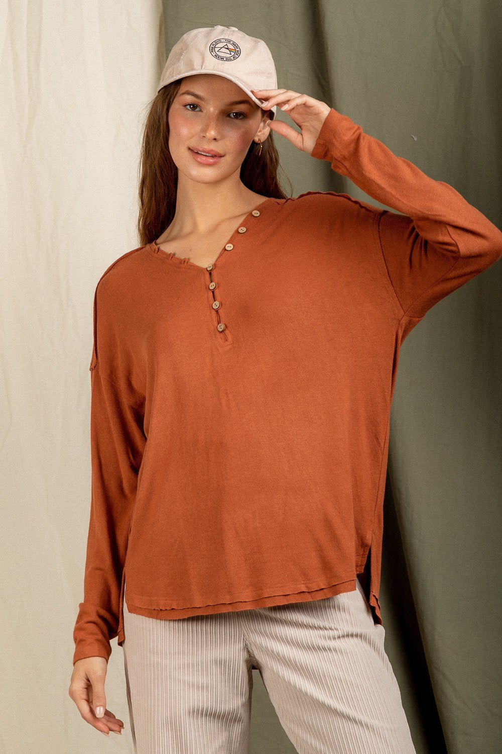 Model wearing OH SO SOFT V-NECK TOP BRICK/MOCHA from Raggdoll Boutique, showcasing trendy coastal style.