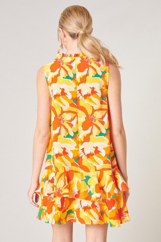 Back view of a vibrant floral dress from Raggdoll Boutique, perfect for vacation wardrobe: IN THE TROPICS.
