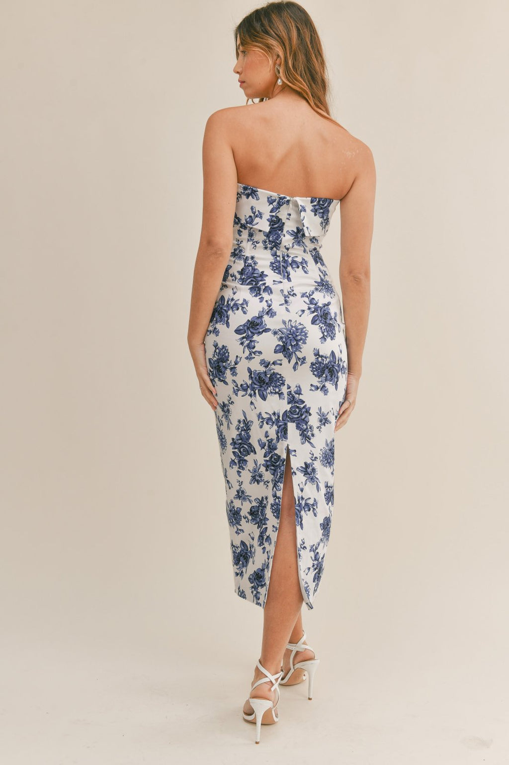Back view of a woman wearing the Best Wedding Guest Dress from Raggdoll Boutique with floral print.