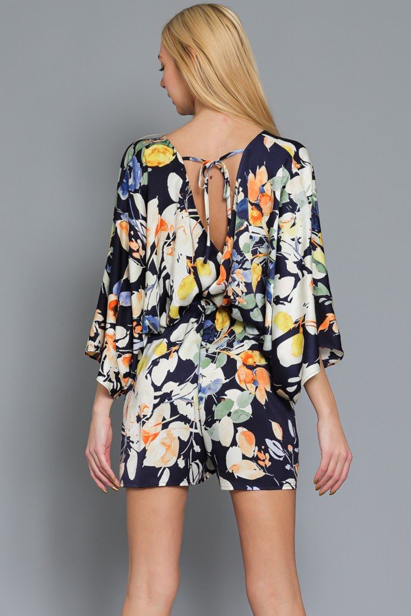 Back view of FUN KIMONO SLEEVE NAVY/MULTI ROMPER showcasing floral design, perfect for vacation wardrobe boutique.