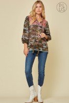 Model wearing CAMO LS EMBROIDERED TOP paired with jeans and boots from Raggdoll Boutique, showcasing trendy coastal style.