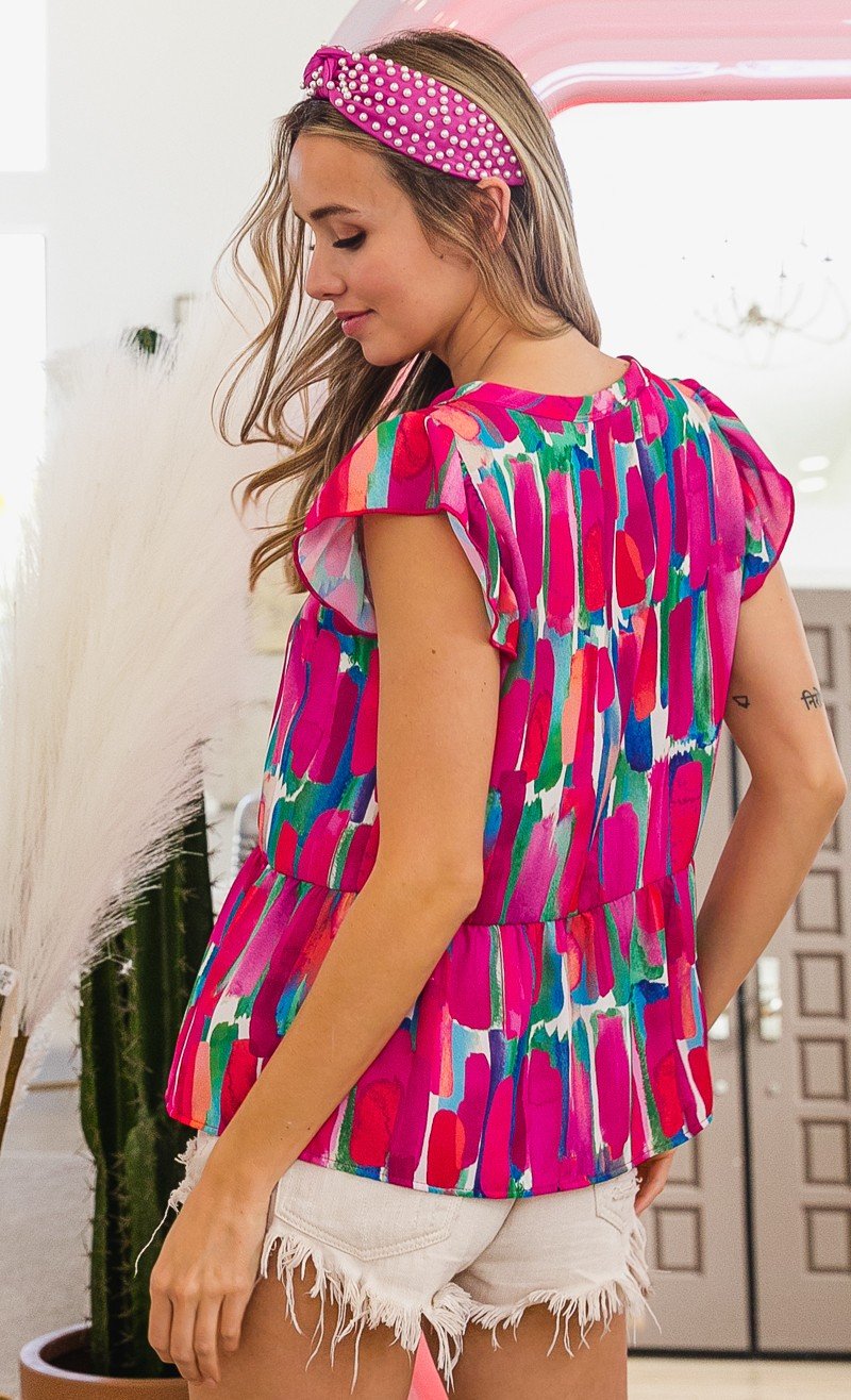 FUSHIA AND BLUE TOP showcased on model, featuring ruffled sleeves and colorful design, ideal for summer outfits Texas.