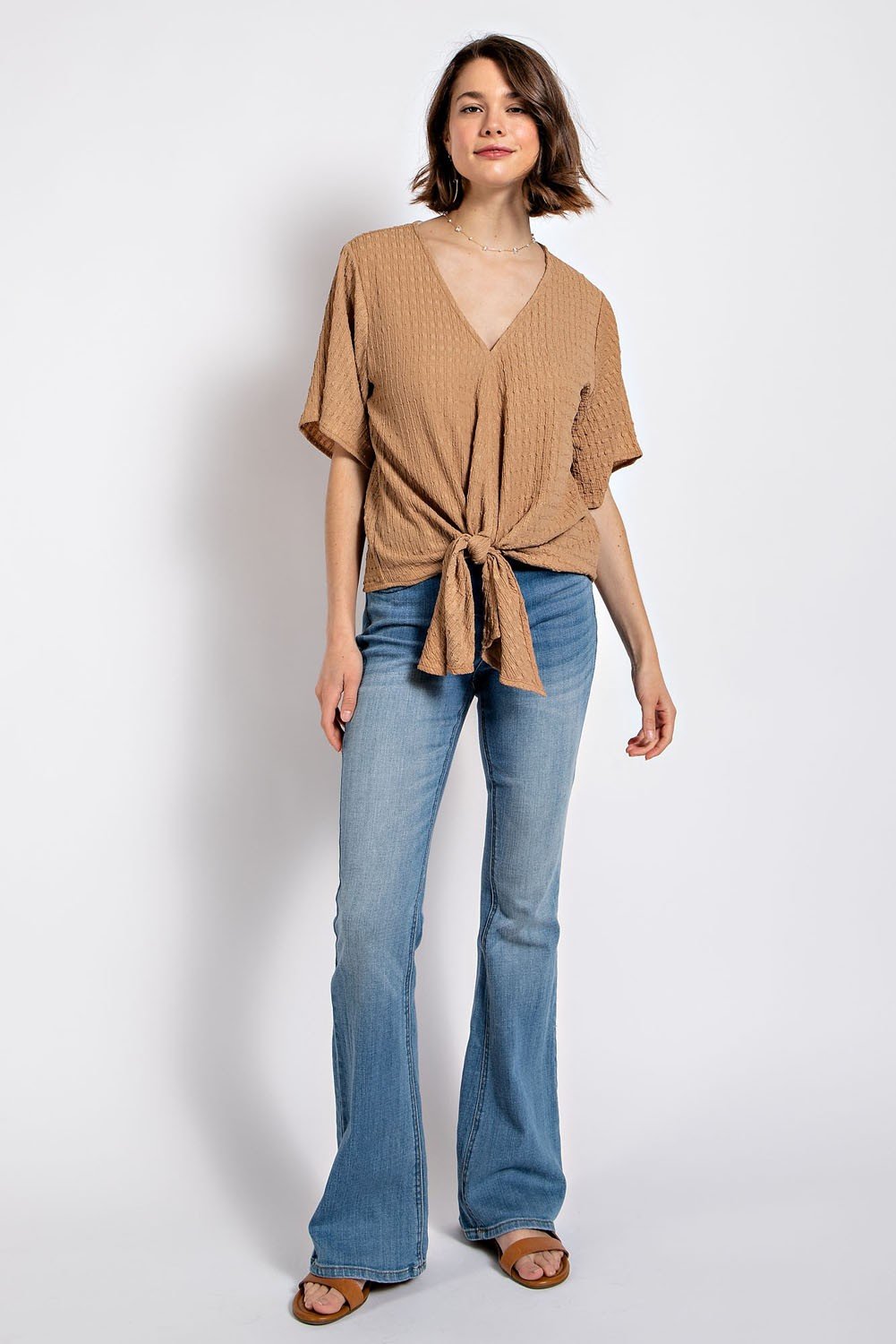 Latte textured tie-front top styled with flared jeans, showcasing coastal boutique clothing for curvy plus size fashion.