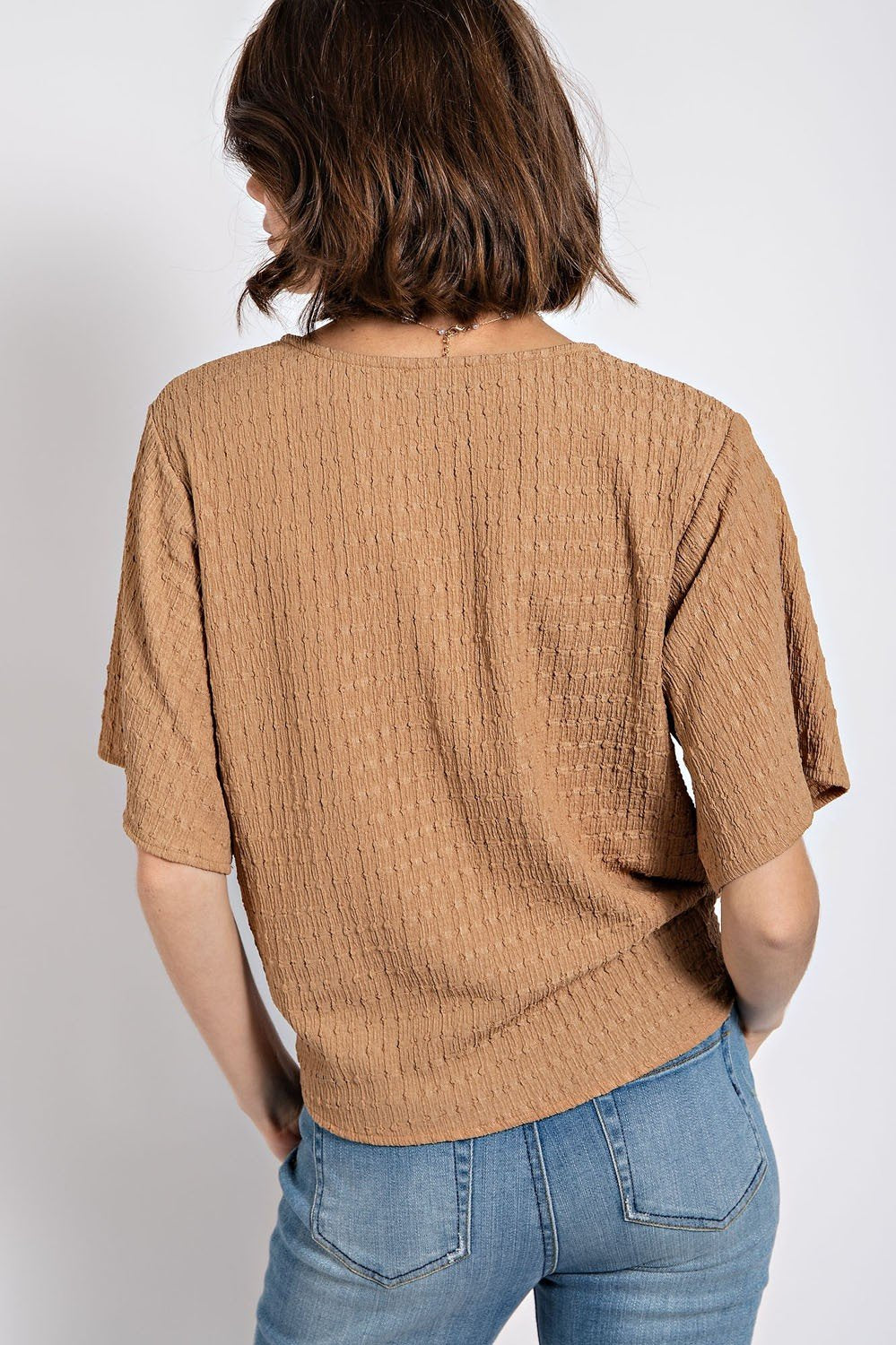 Back view of latte textured tie-front top in tan, a stylish women's top for coastal boutique clothing and curvy fashion.