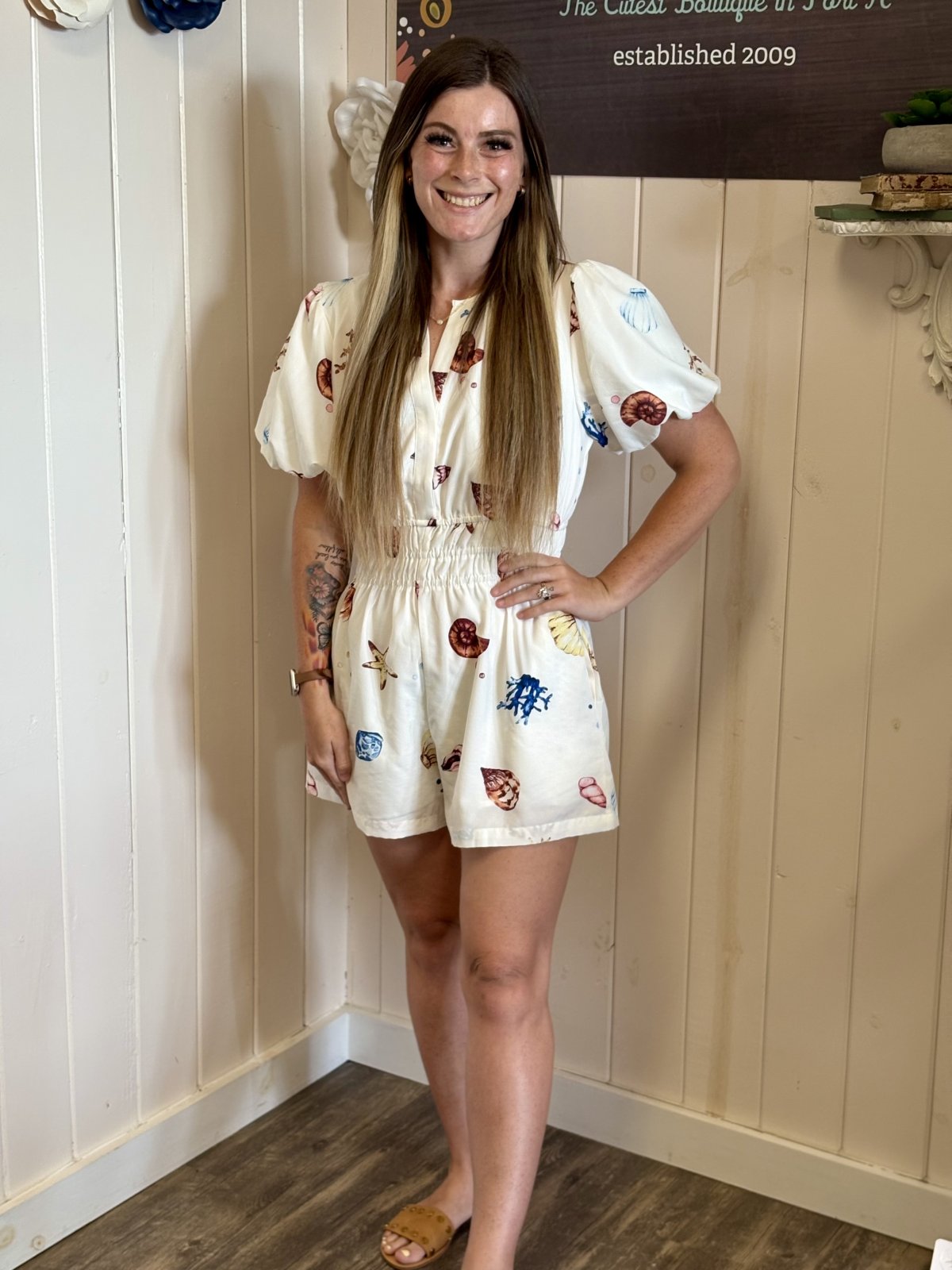 Off-white shell print romper with puff sleeves, side pockets and a stylish slit neck, ideal for coastal boutique clothing.