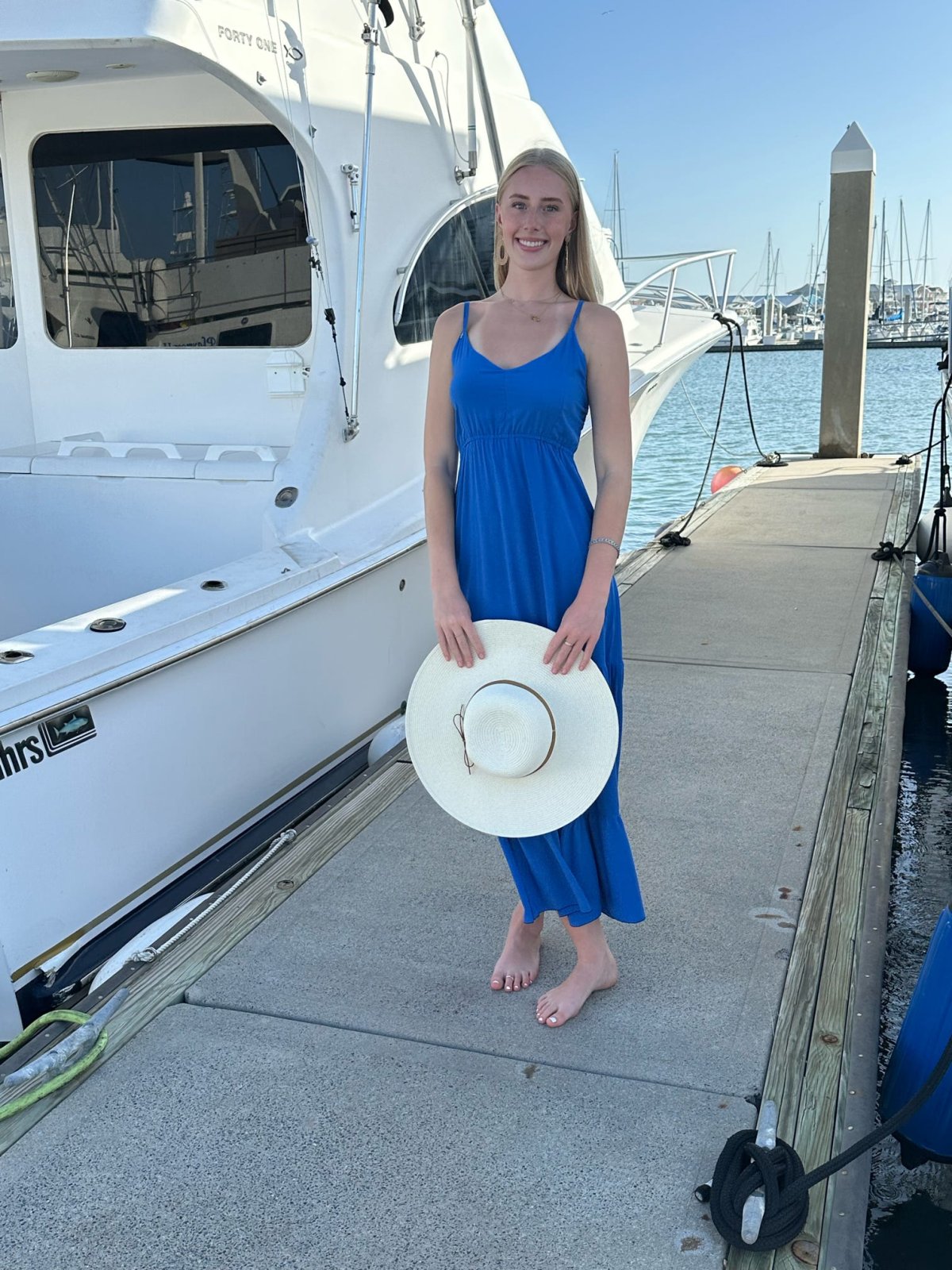 Model wearing Brielle Dress by Raggdoll Boutique, showcasing trendy coastal style at marina.