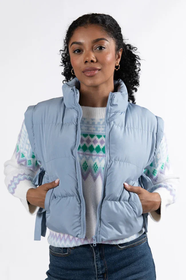 Trendy powder blue vest with side bows paired with a cozy sweater, perfect for coastal boutique clothing outfits.