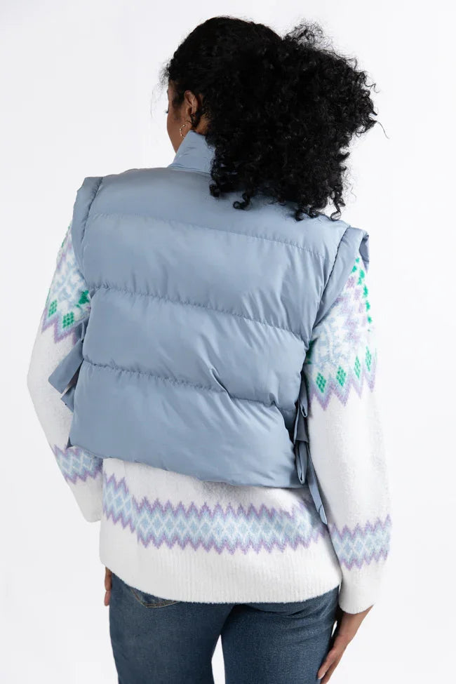 Back view of a powder blue vest with side bows, styled with a colorful sweater, perfect for coastal boutique clothing.