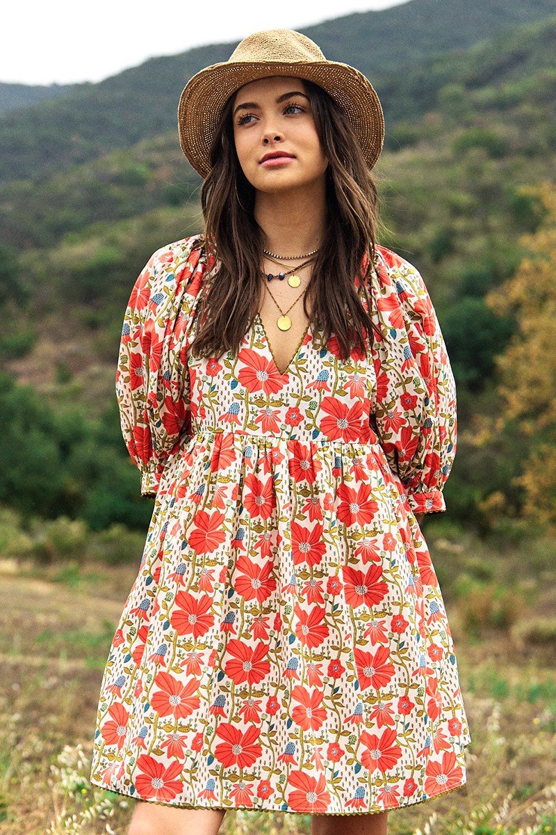 Model wearing a floral Paige Dress from a coastal boutique, perfect for beach outings and tropical vacations.