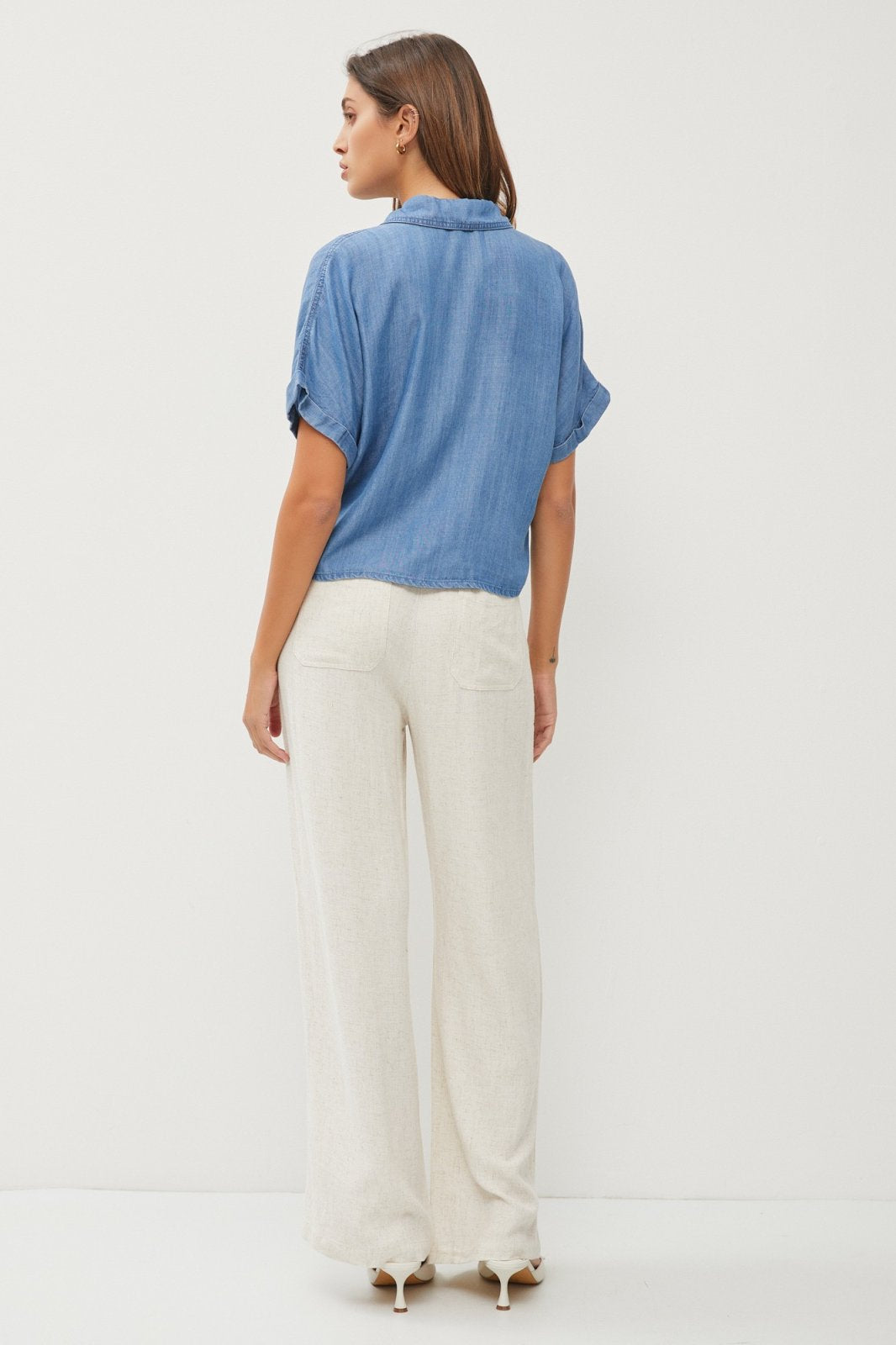 Model wearing Medium Tencel Denim Tie-Front Top with light pants from Raggdoll Boutique.