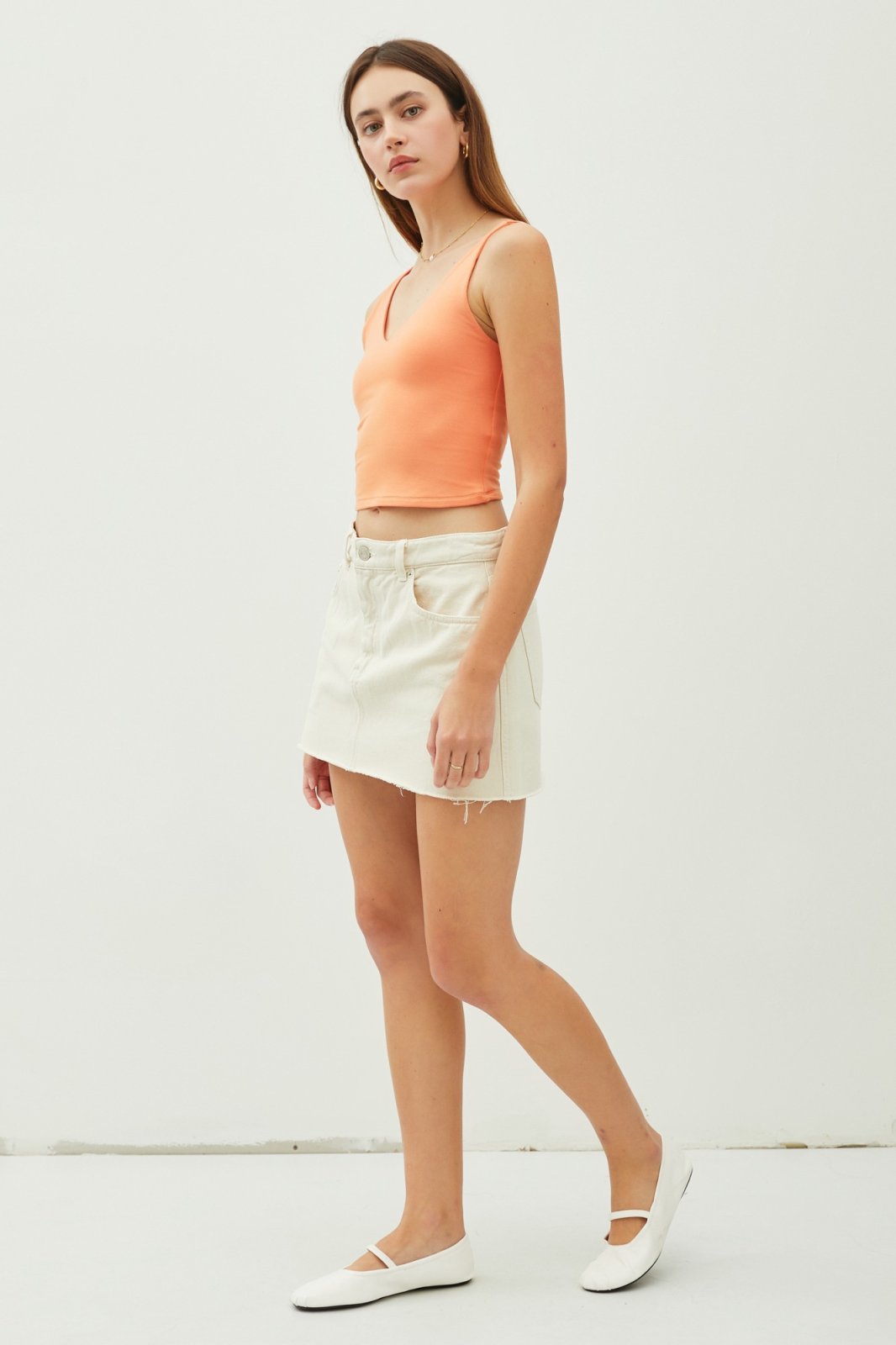 Tangerine double-lined crop tank top styled with a white skirt, perfect for coastal boutique clothing and summer outfits.