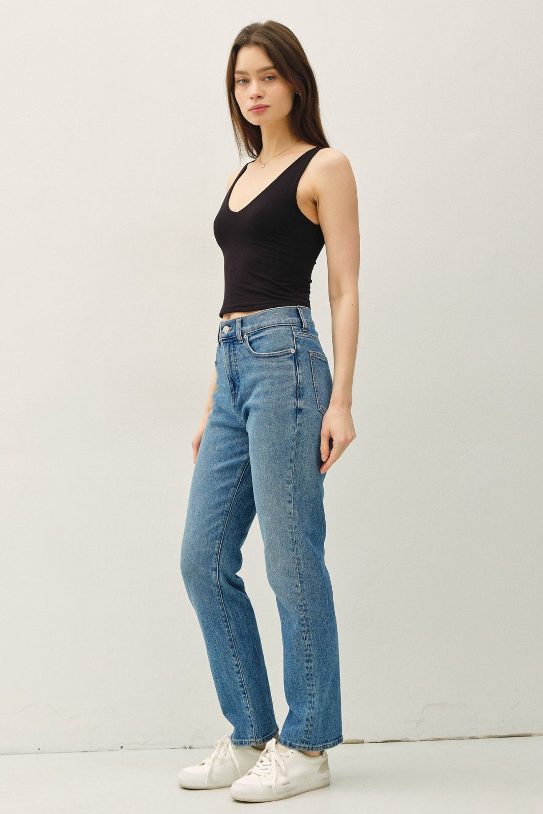 Model wearing a black double-lined crop tank top with high-waisted jeans, showcasing coastal boutique clothing style.