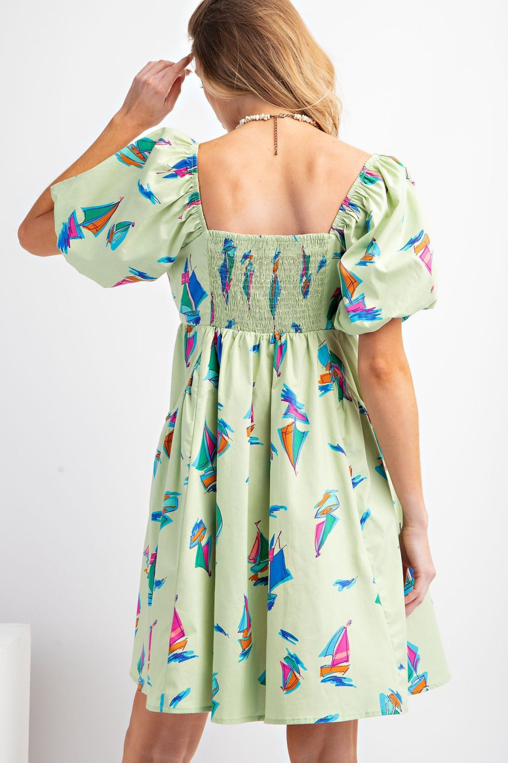 Back view of the stylish Cali Dress featuring colorful sailboat print, perfect for Port Aransas beach outings.