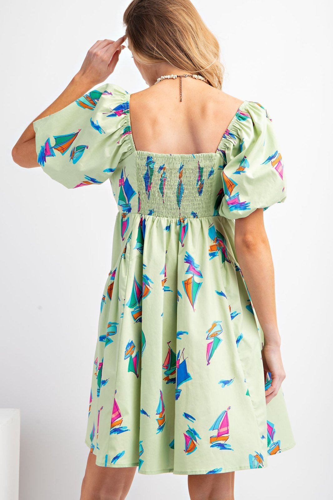 Back view of the stylish Cali Dress featuring colorful sailboat print, perfect for Port Aransas beach outings.