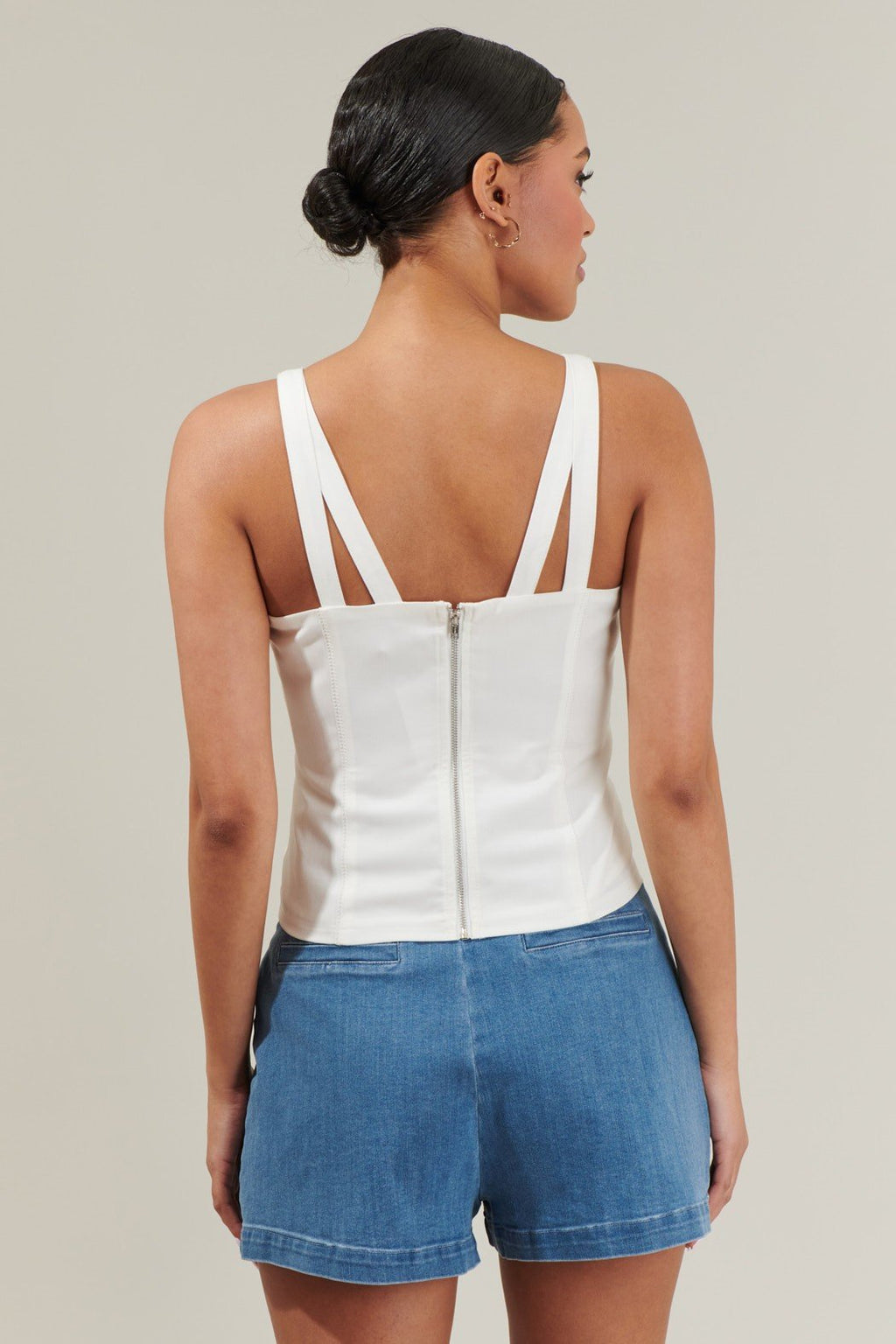 Back view of Haille Bustier Top with belt buckle straps, paired with denim shorts, from Raggdoll Boutique.