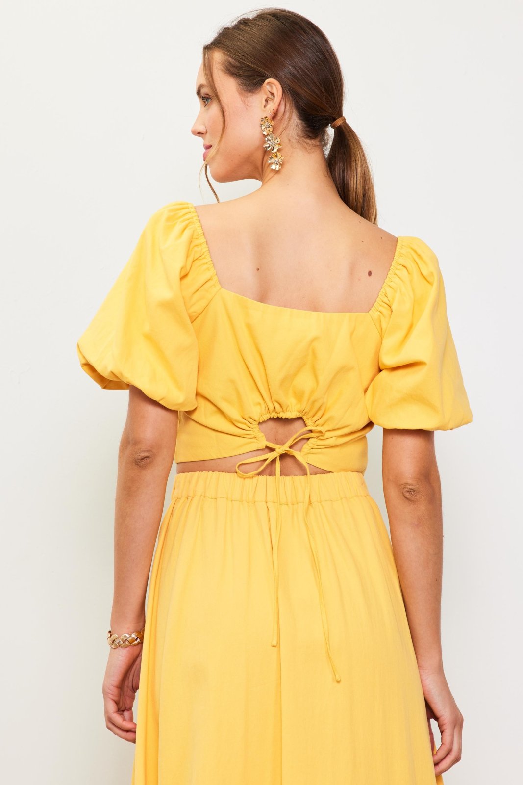 Stylish yellow sunflower top with open back, perfect for coastal boutique clothing and tropical vacation dresses.