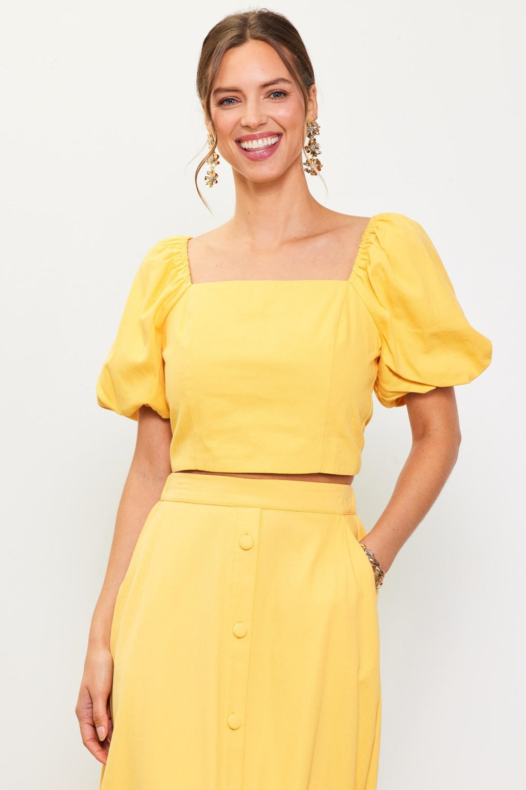 Stylish yellow puff sleeve top from a coastal boutique, perfect for tropical vacations and curated women's fashion.