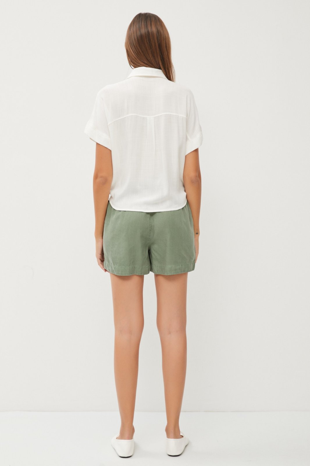 Off-White Linen Tie Front Top worn with green shorts, showcasing trendy coastal style from Raggdoll Boutique.