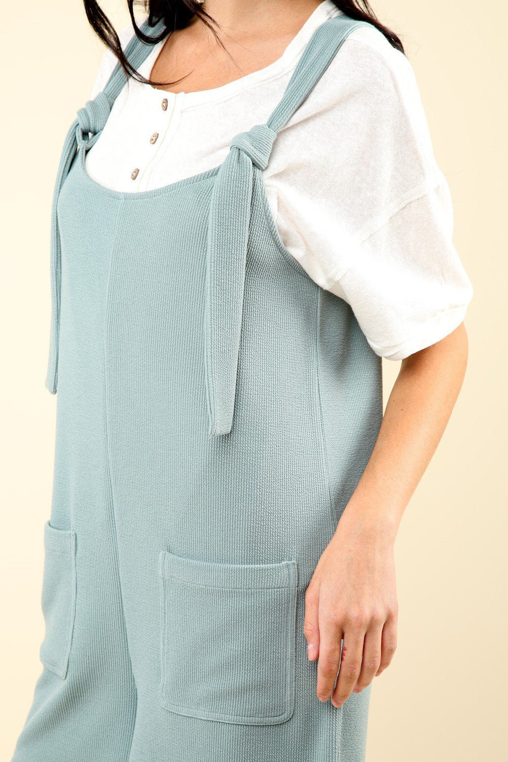 Riley Romper in sage with shoulder tie detail and front patch pockets, ideal for coastal boutique clothing and tropical vacations.
