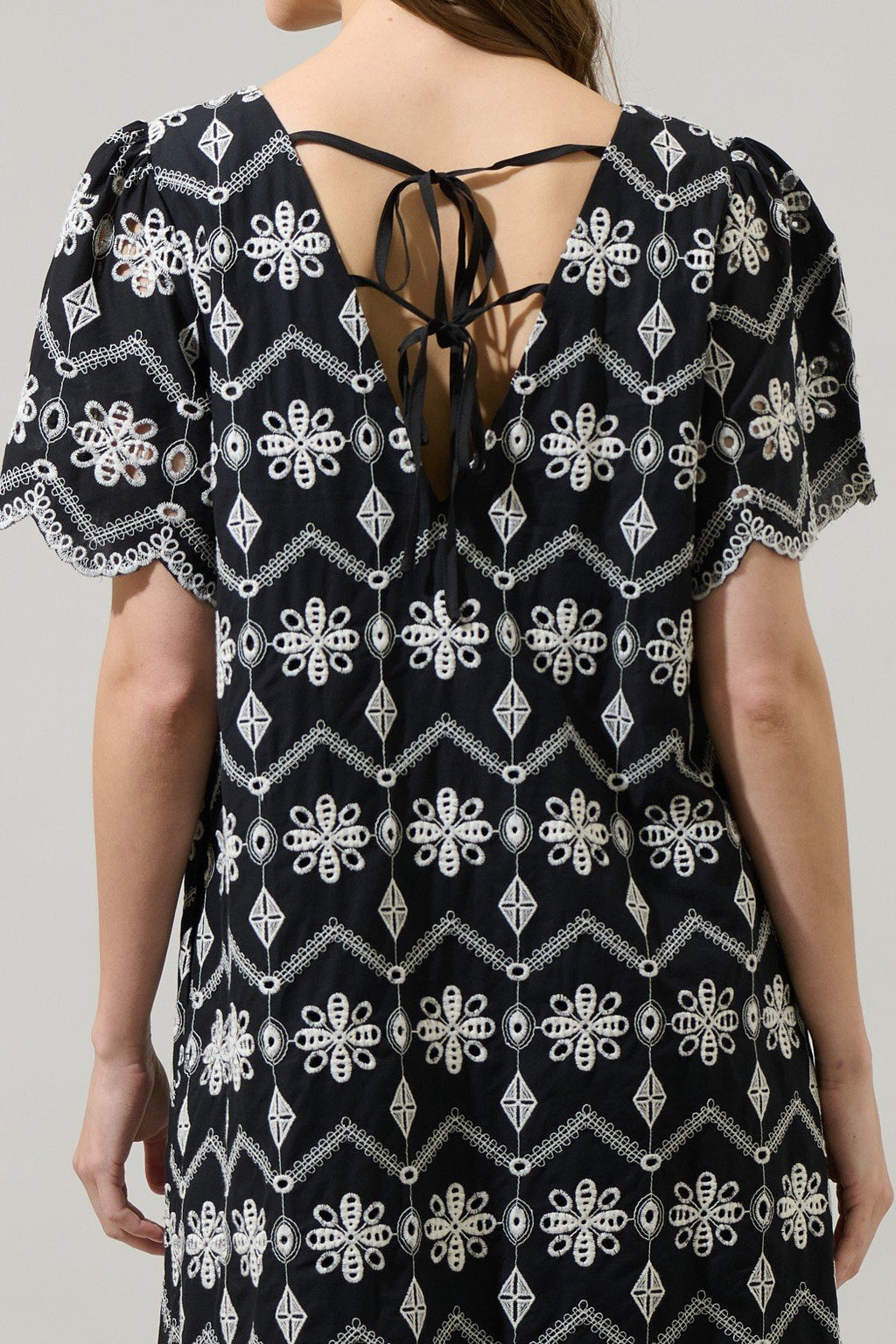 Back view of Libby Dress featuring intricate floral embroidery and tie closure, by Raggdoll Boutique, perfect for coastal fashion.