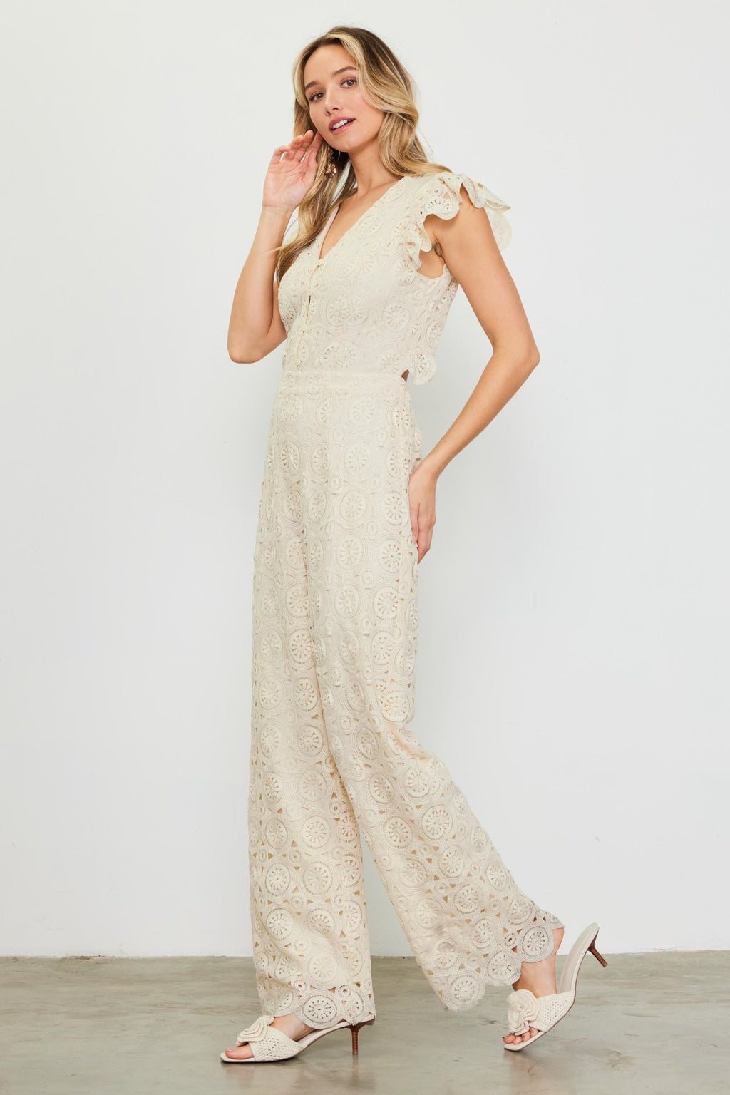 Ivory crochet jumpsuit from a coastal boutique, perfect for tropical vacations and stylish beach outings.