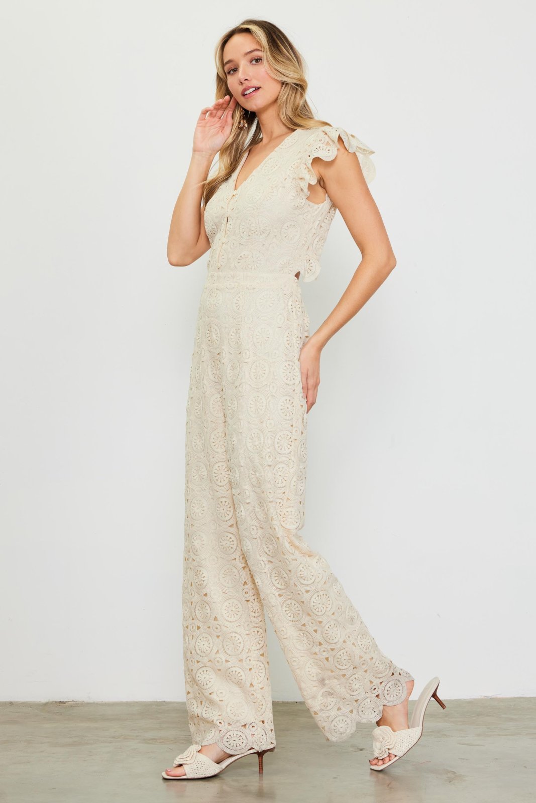 Ivory crochet jumpsuit from a coastal boutique, perfect for tropical vacations and stylish beach outings.