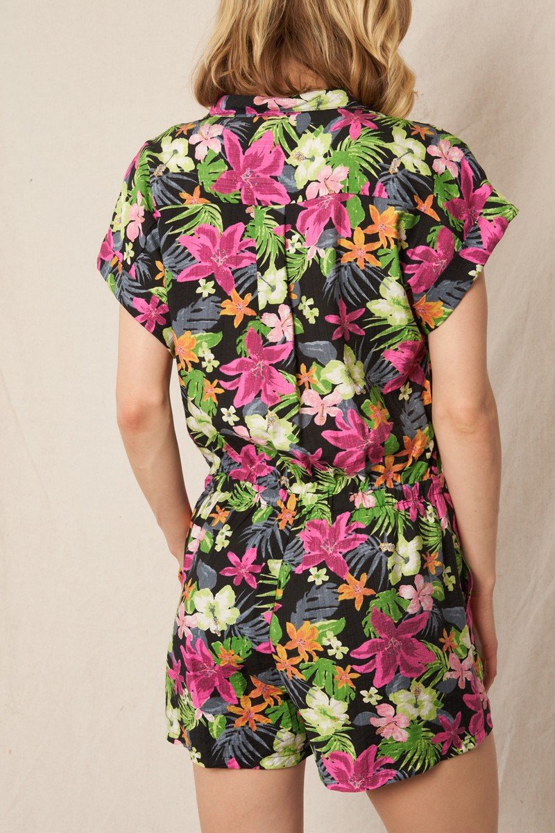 Back view of FUN FLORAL ROMPER BLACK/MAGENTA featuring vibrant floral print, ideal for coastal fashion boutique.